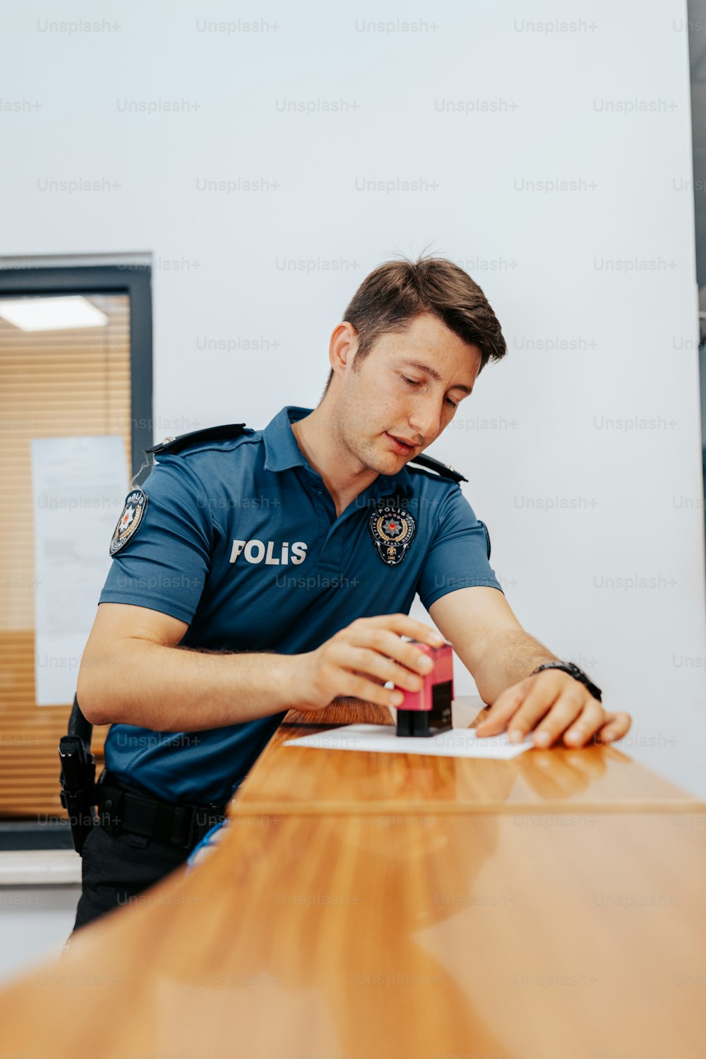 Un oficial de policía sentado en una mesa escribiendo en un pedazo de papel