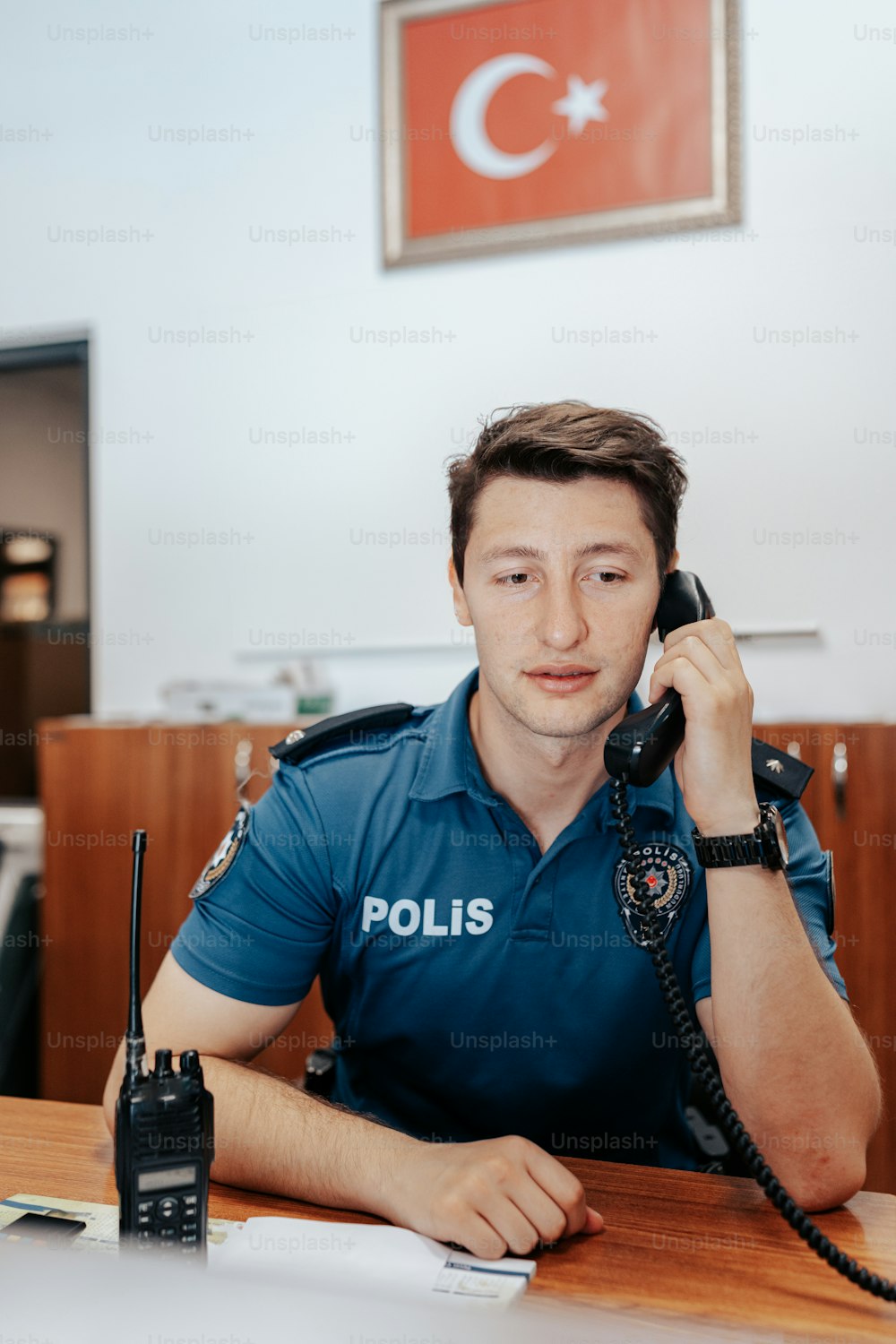 a man sitting at a table talking on a phone