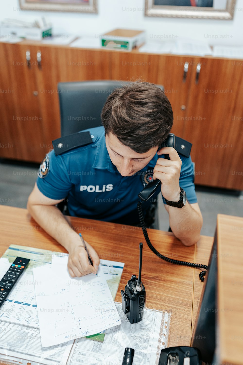 um policial sentado em uma mesa em um escritório
