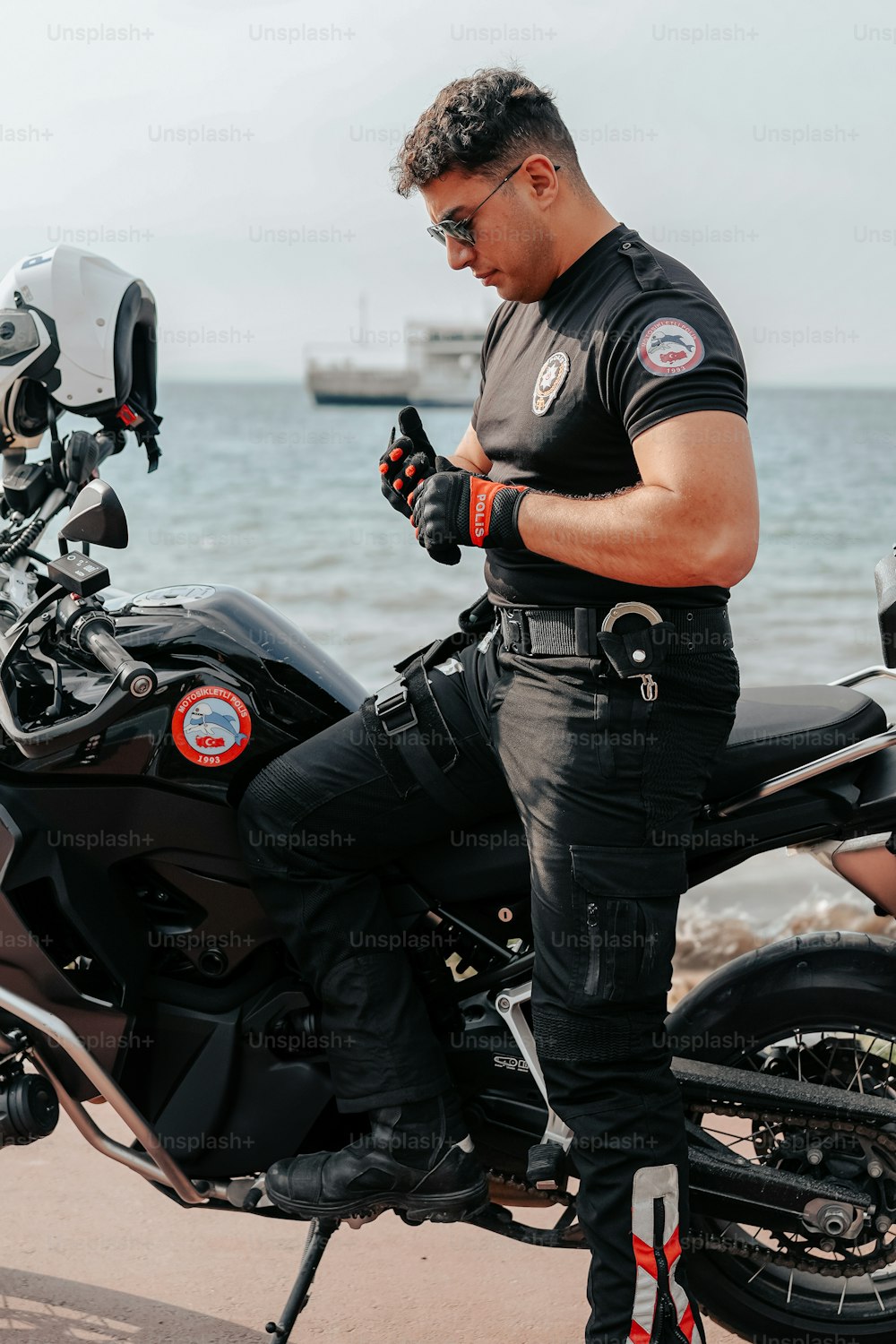a man sitting on a motorcycle looking at his cell phone