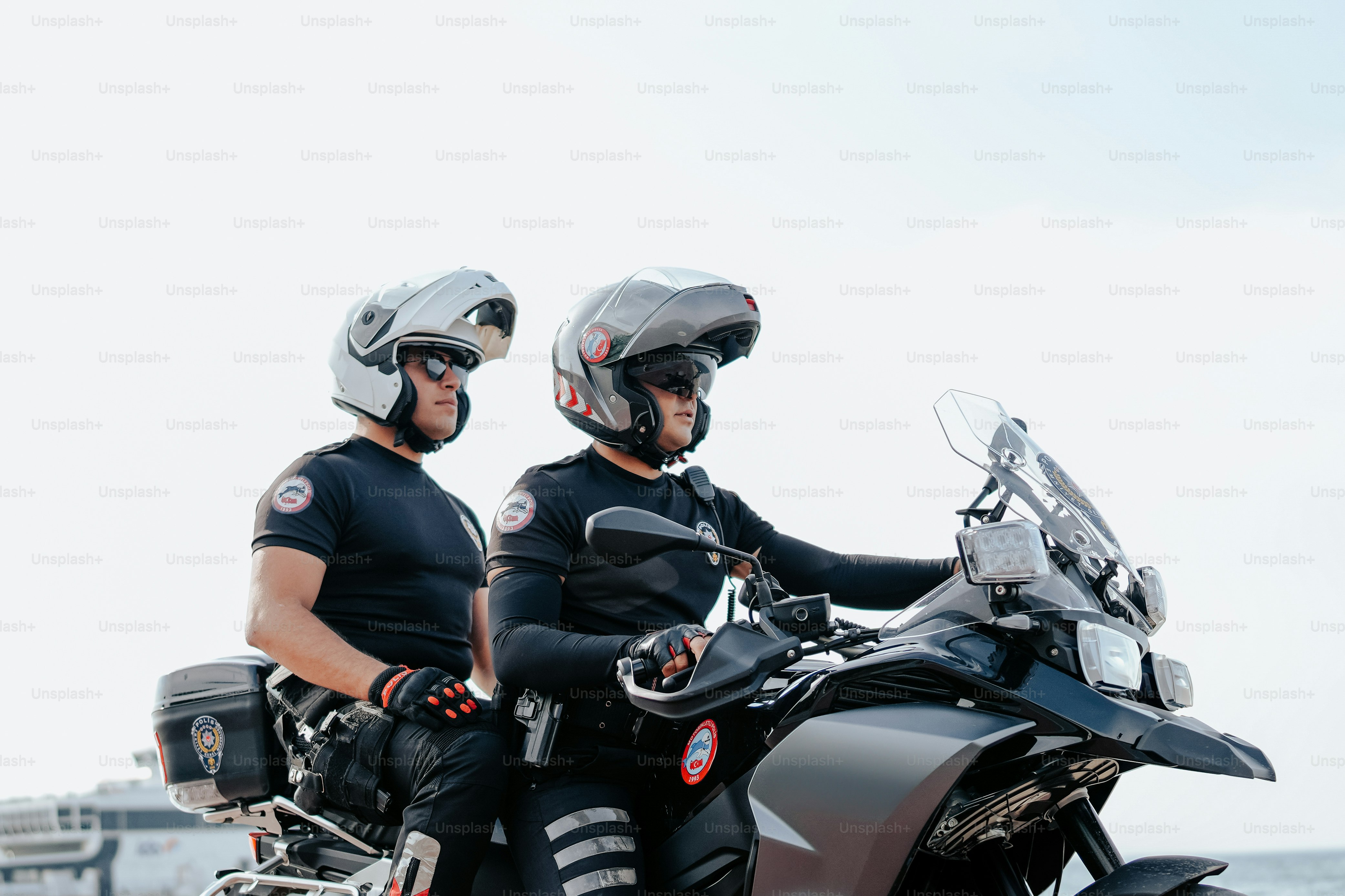 a couple of men riding on the back of a motorcycle