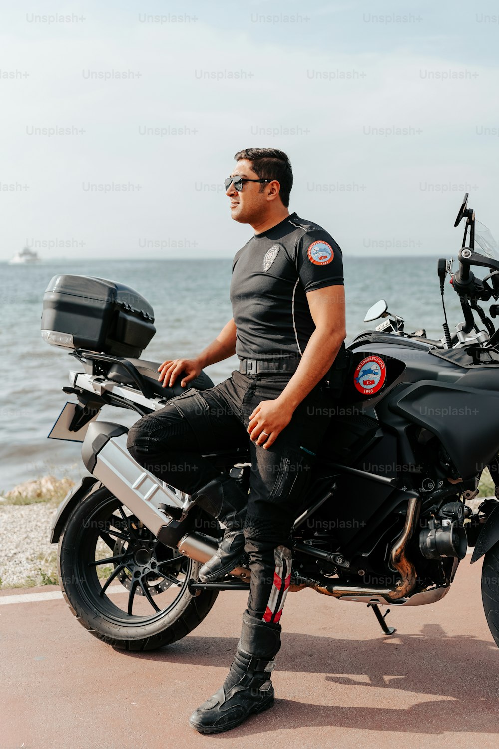 Un hombre sentado en una motocicleta cerca del océano