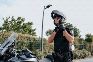 Un uomo che indossa un casco e guanti in piedi accanto a una motocicletta