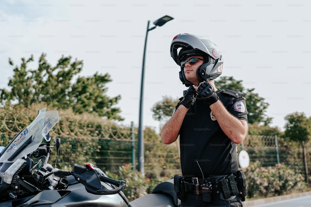 a man wearing a helmet and gloves standing next to a motorcycle