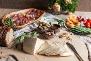a variety of cheeses and meats on a cutting board