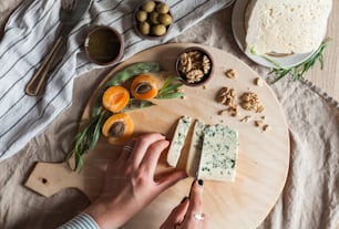 a person is cutting cheese on a cutting board