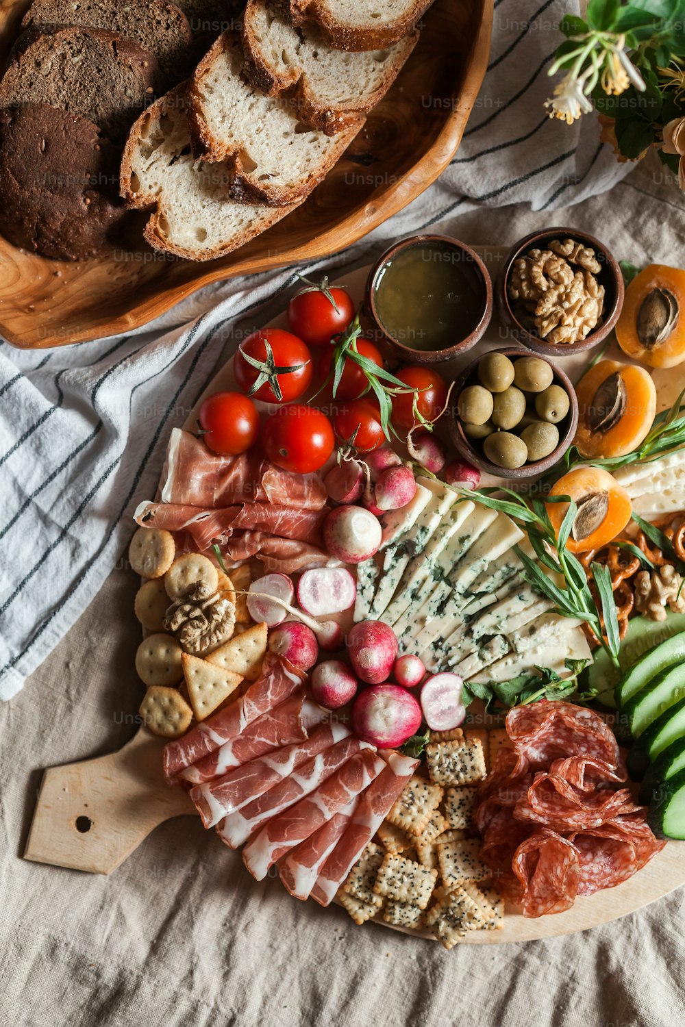 un plato de carnes, quesos, panes y verduras