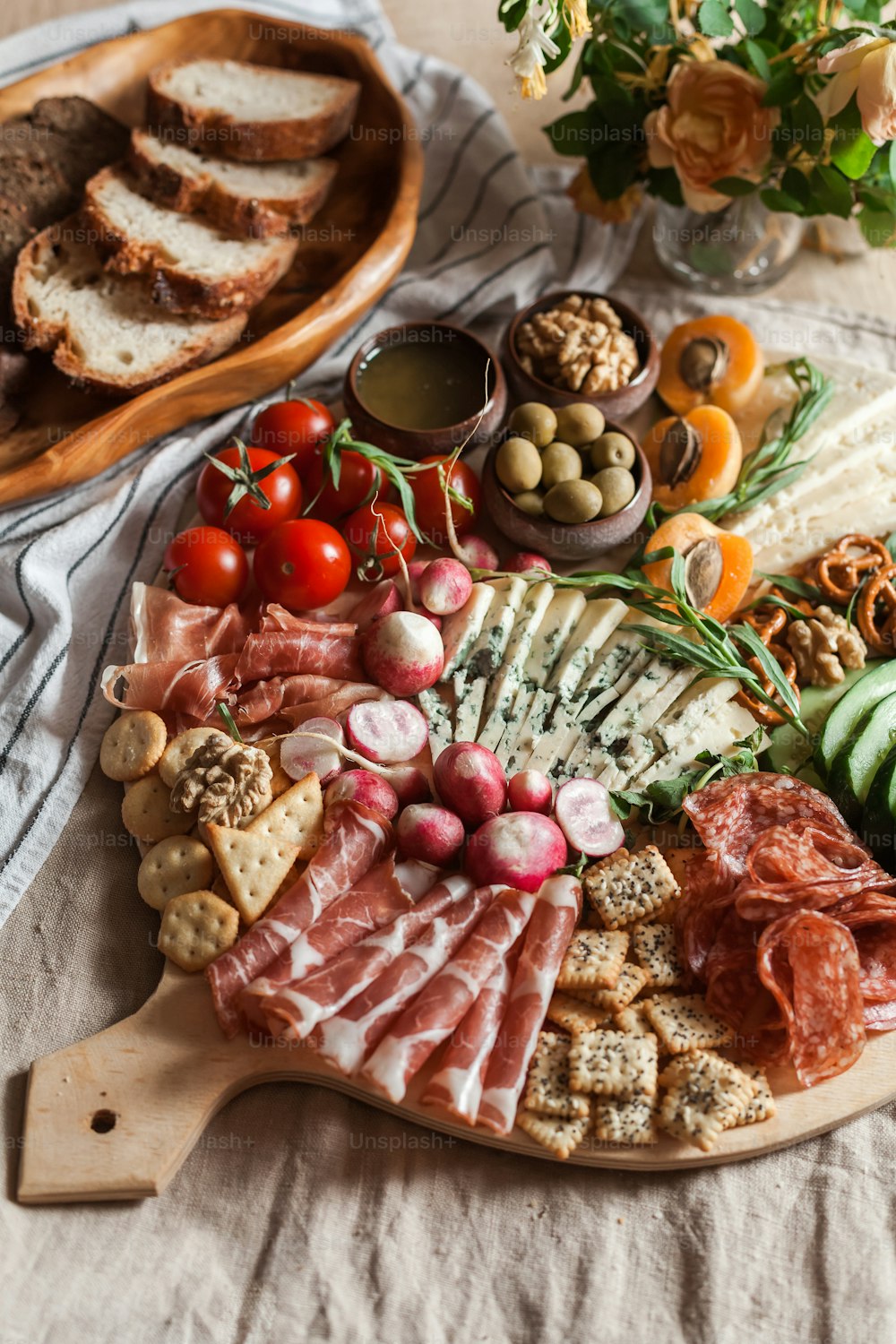 eine Platte mit Fleisch, Käse, Brot und Gemüse