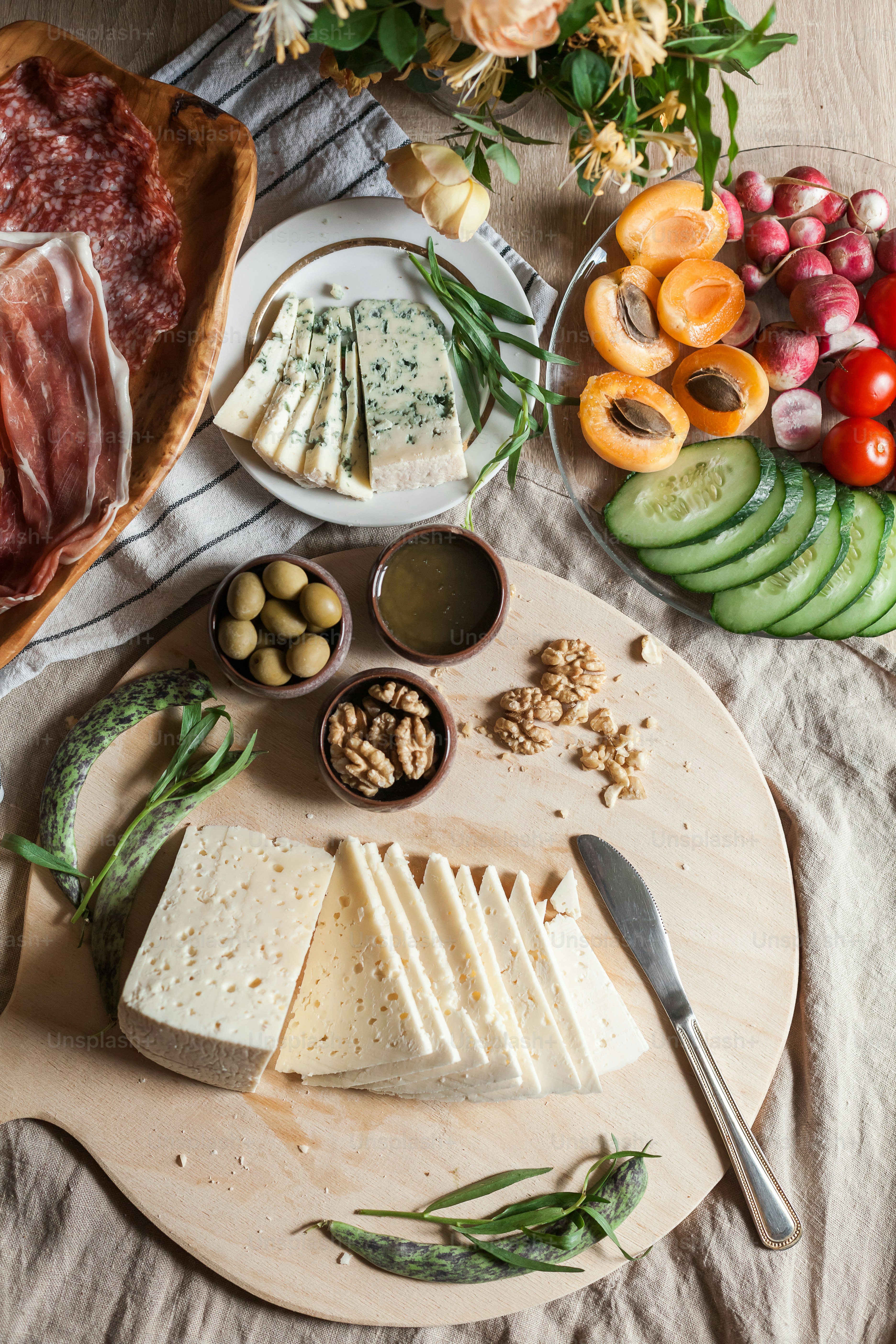 a platter of cheese, meats, and vegetables on a table