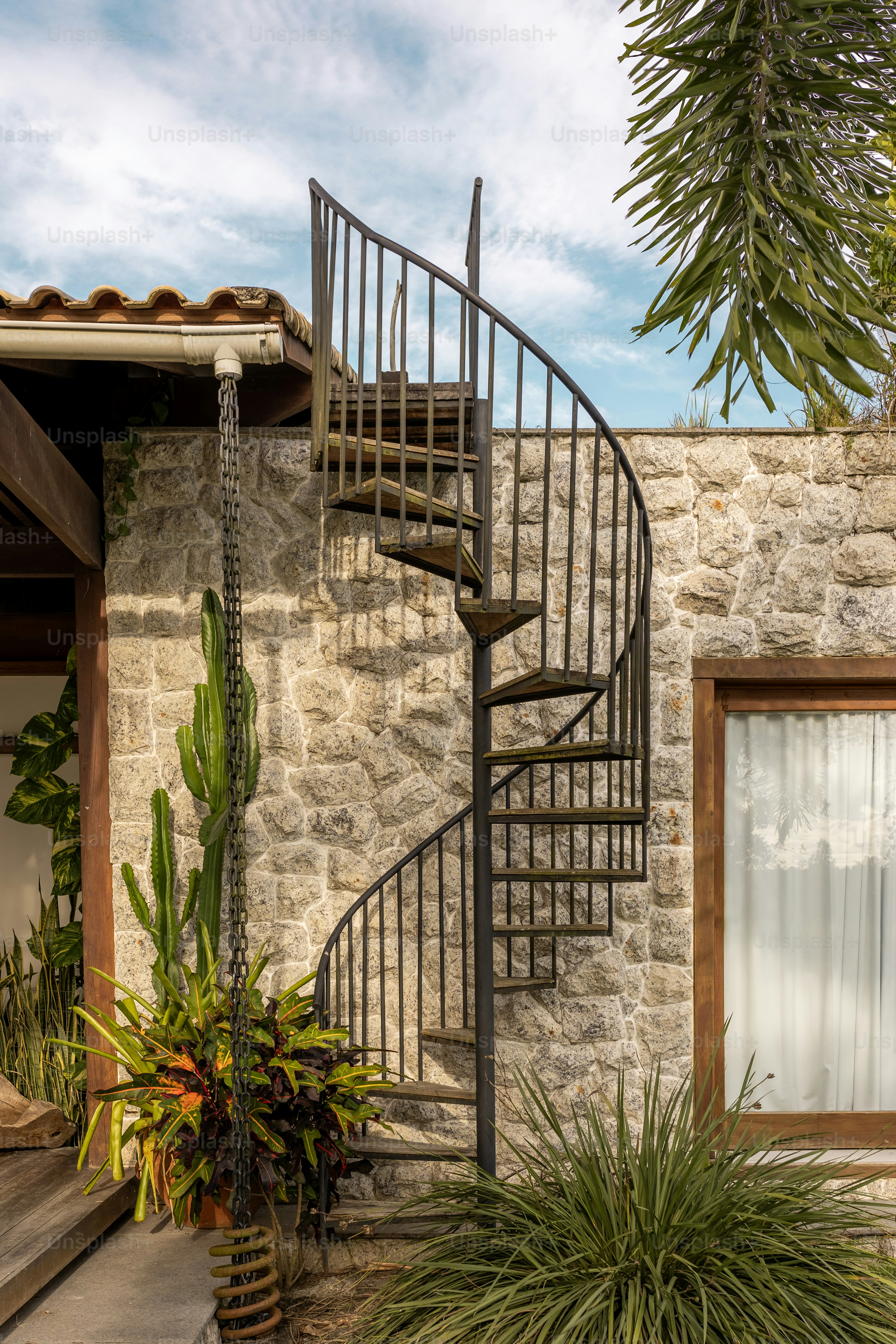 una escalera de caracol de metal junto a un edificio de piedra