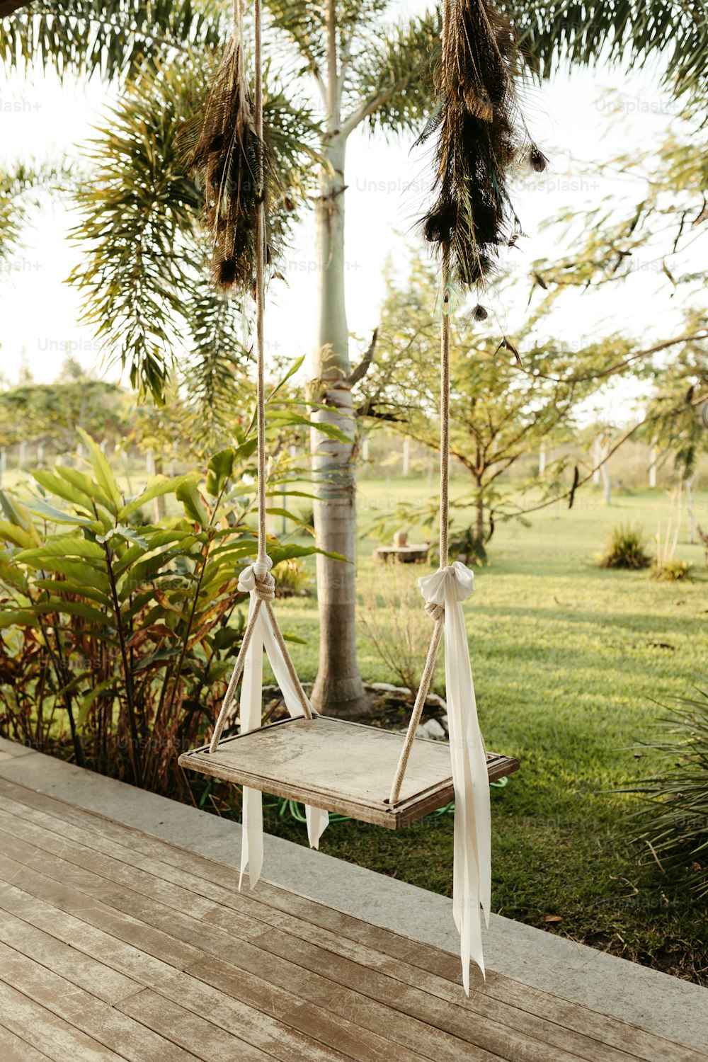 a wooden deck with a swing and a tree