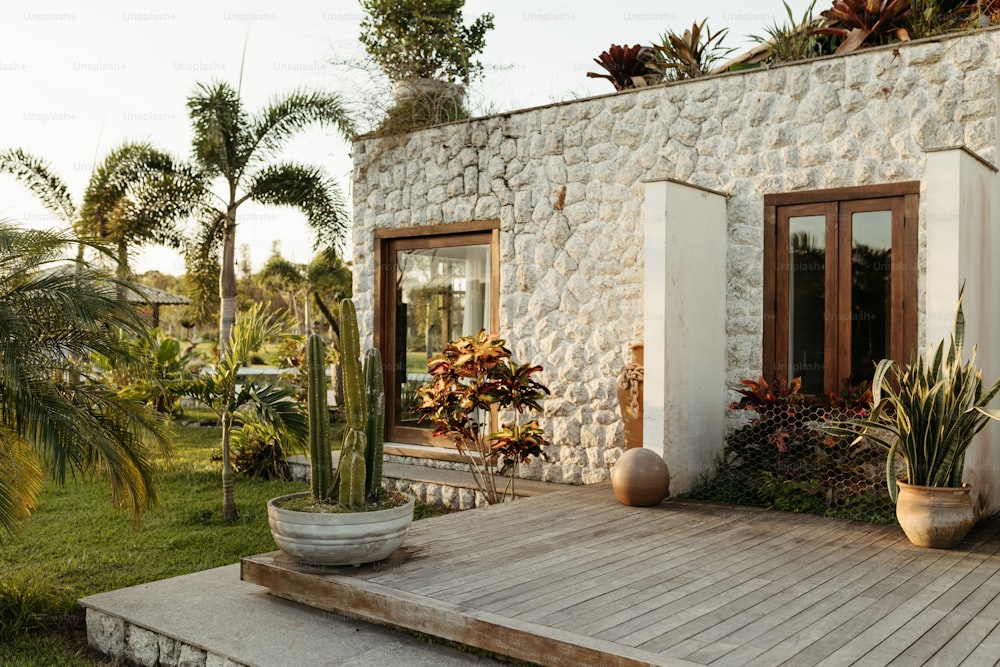 une maison avec une terrasse en bois entourée de plantes