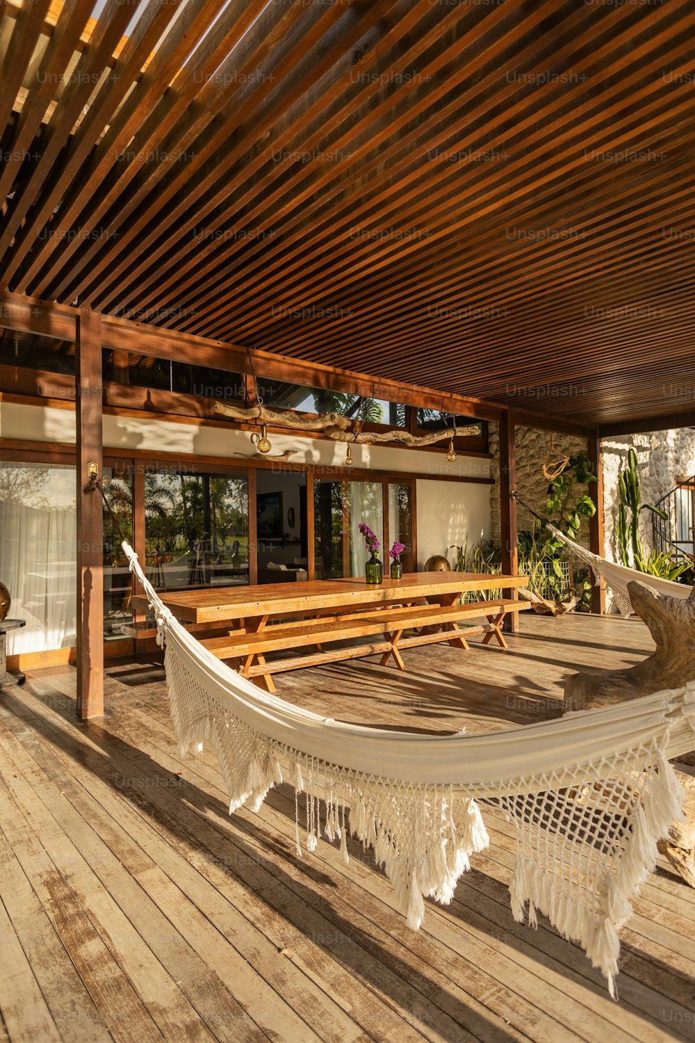 a hammock on a deck with a bench in the background