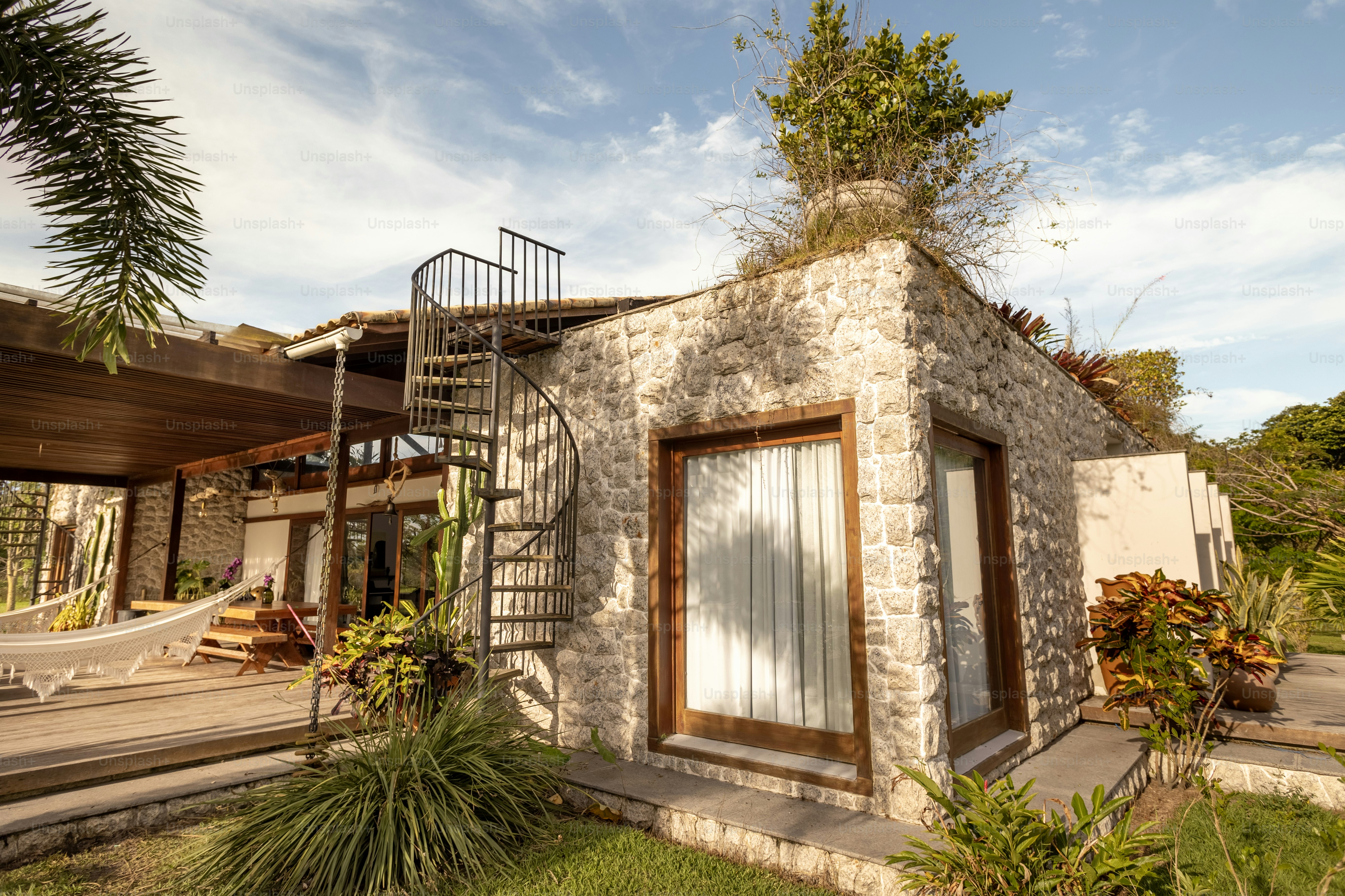 a house with a hammock and a hammock hanging from the roof