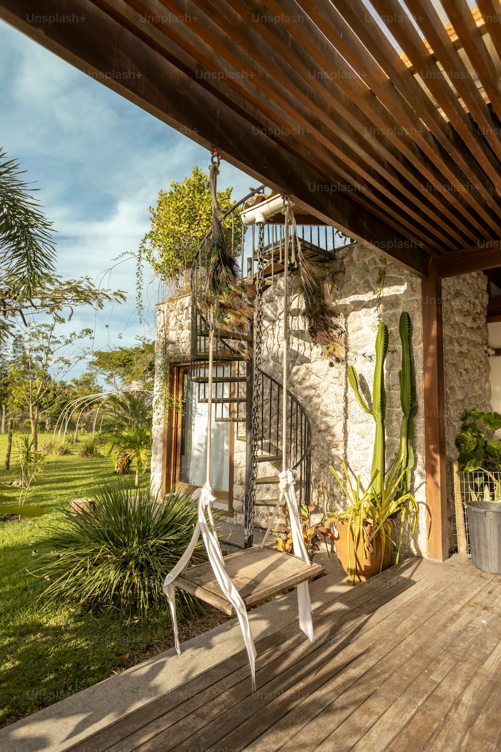 a wooden deck with a chair and a cactus