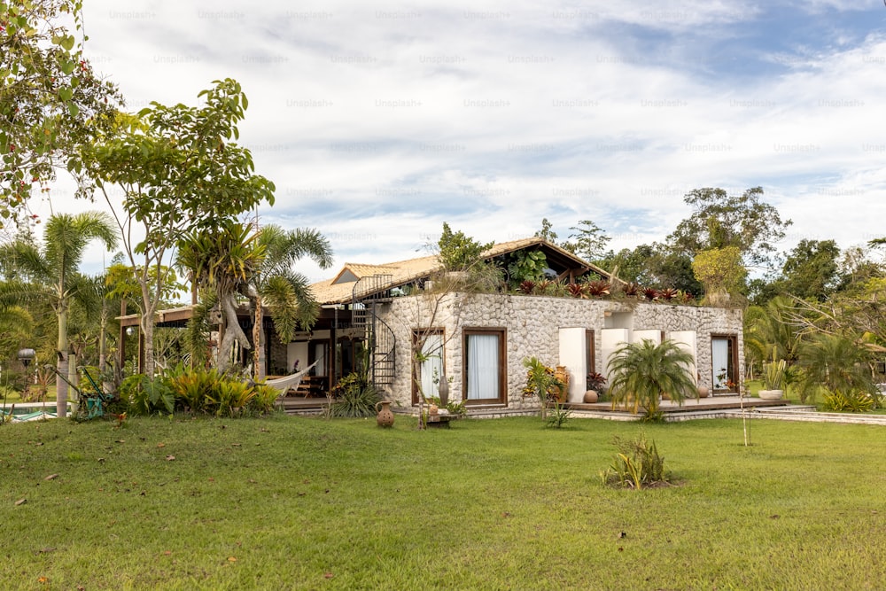 a house in the middle of a lush green field