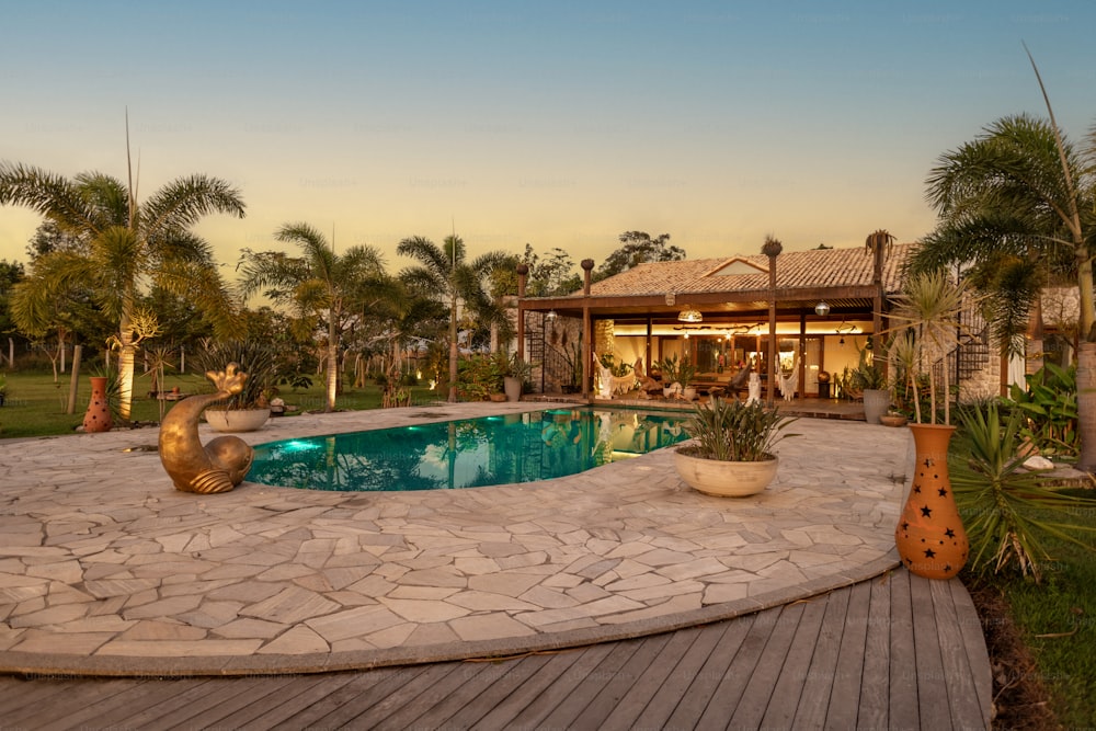 a house with a pool surrounded by palm trees