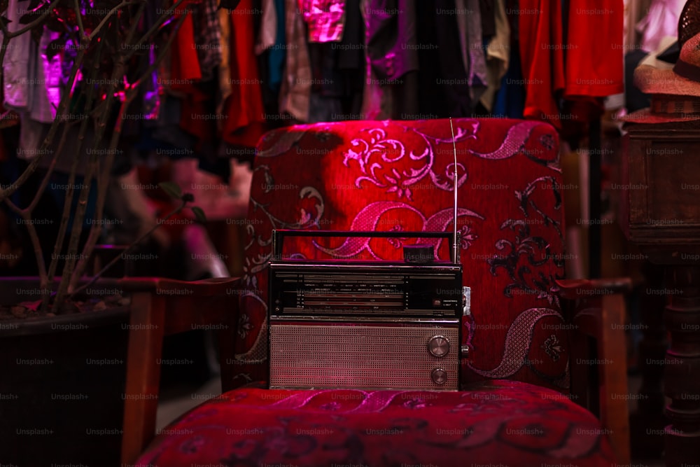 um rádio sentado em uma cadeira vermelha em uma sala