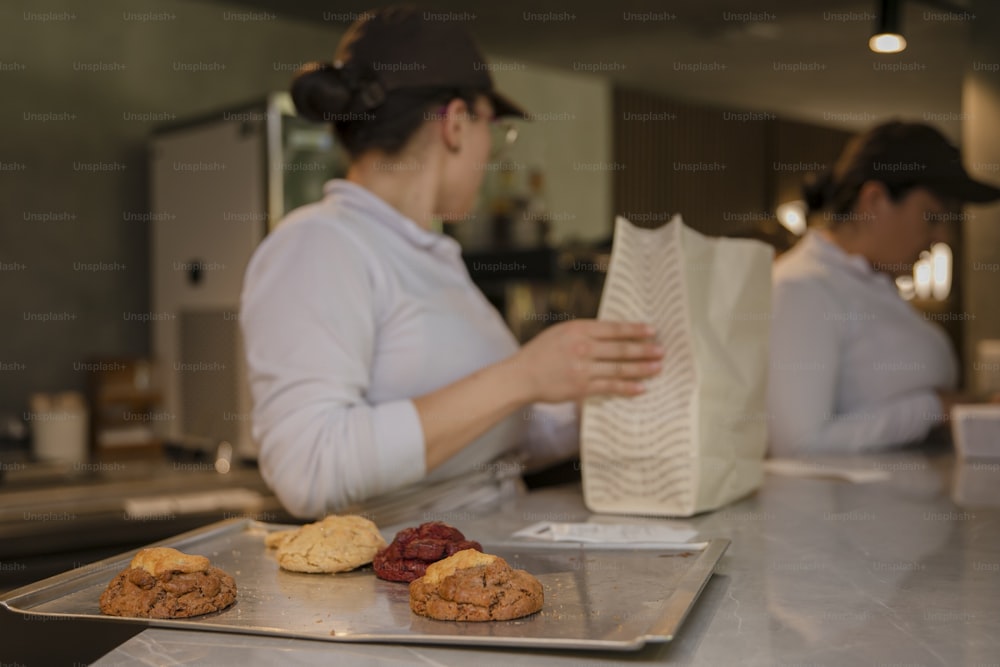 Una mujer en una panadería preparando galletas y galletas