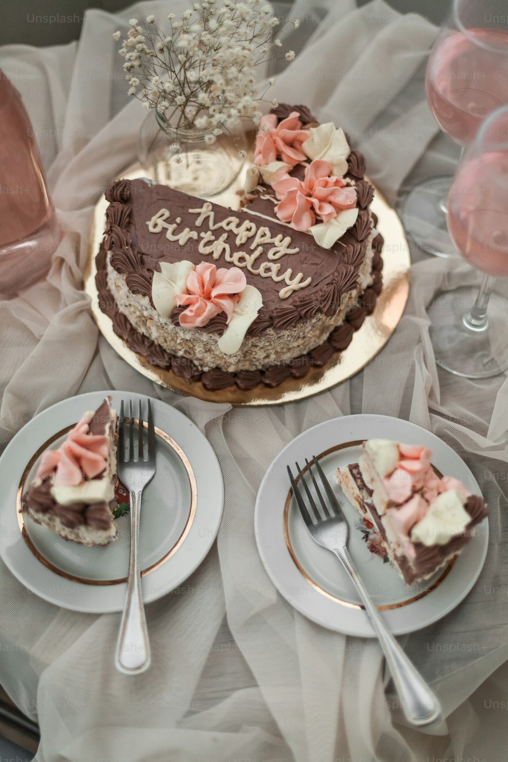 Un pastel de cumpleaños en un plato con un cuchillo y un tenedor