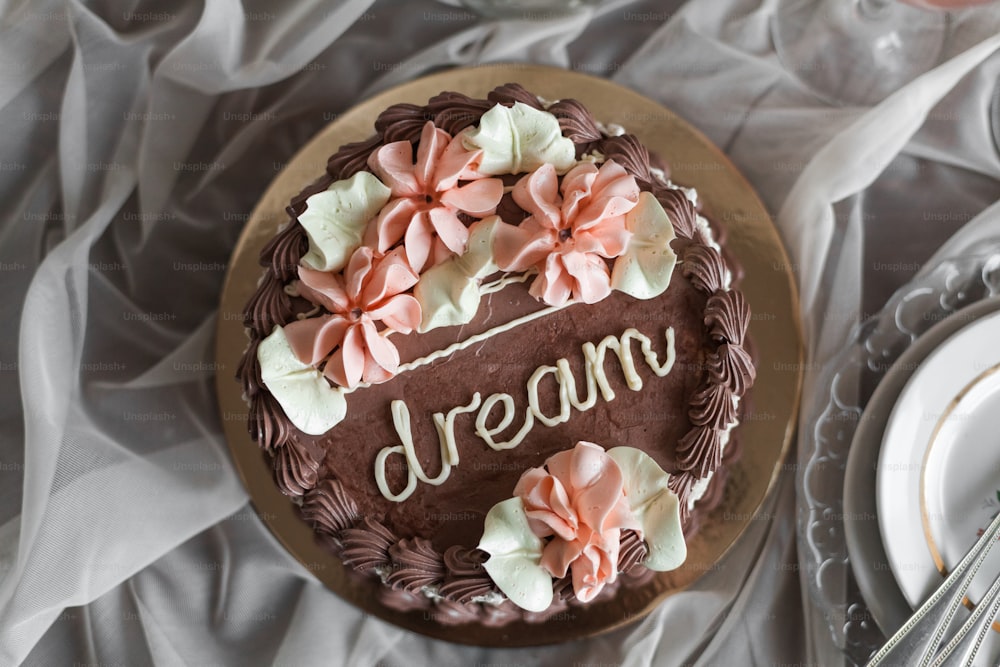 um bolo de chocolate com flores cor-de-rosa por cima