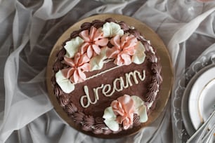 ein Schokoladenkuchen mit rosa Blumen darauf