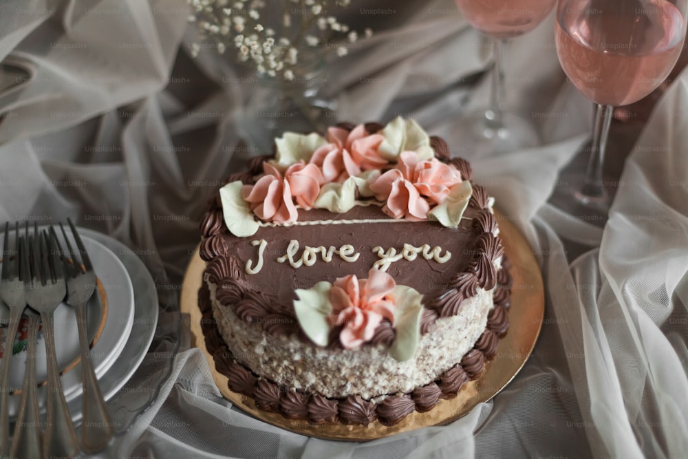 un pastel de chocolate con flores rosadas encima