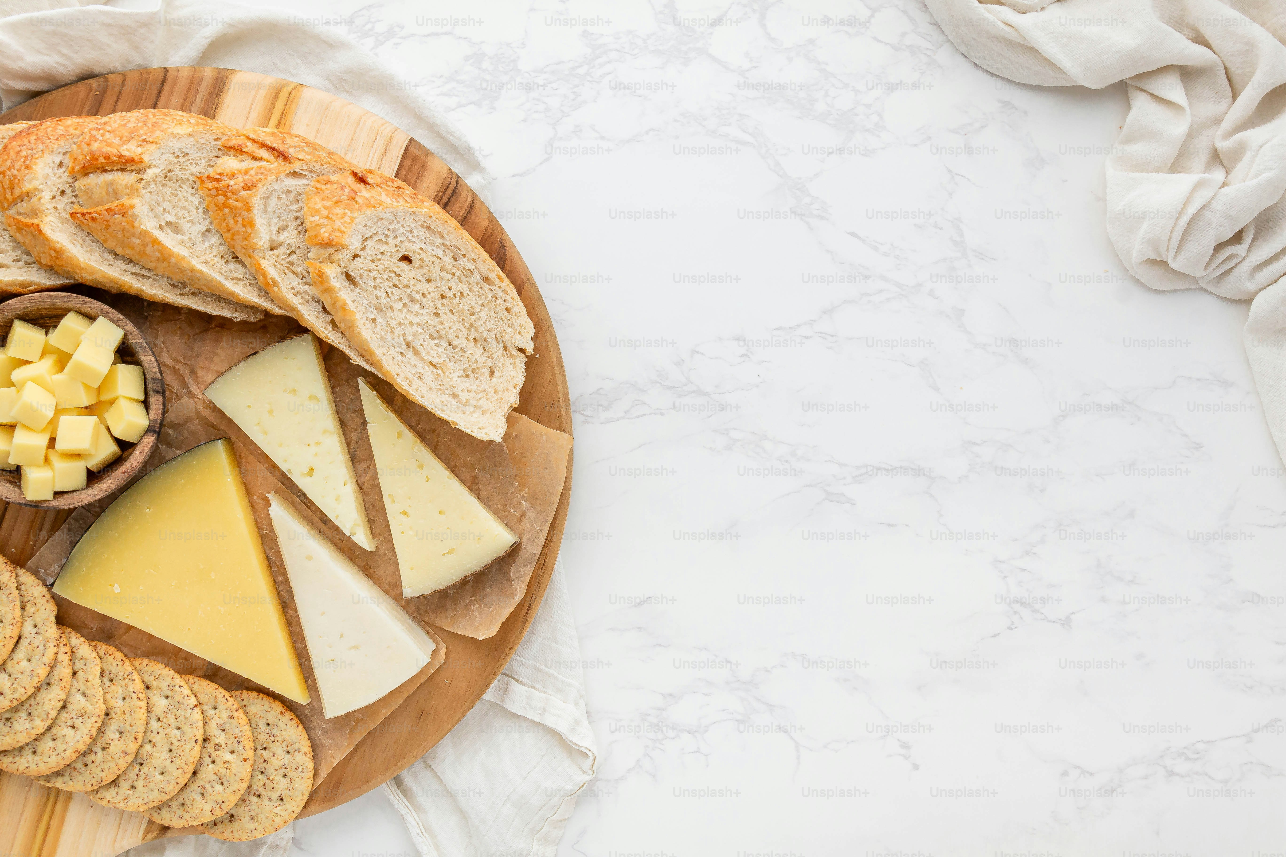 a wooden plate topped with cheese and crackers