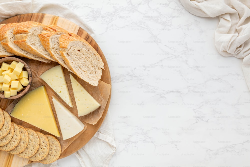 a wooden plate topped with cheese and crackers