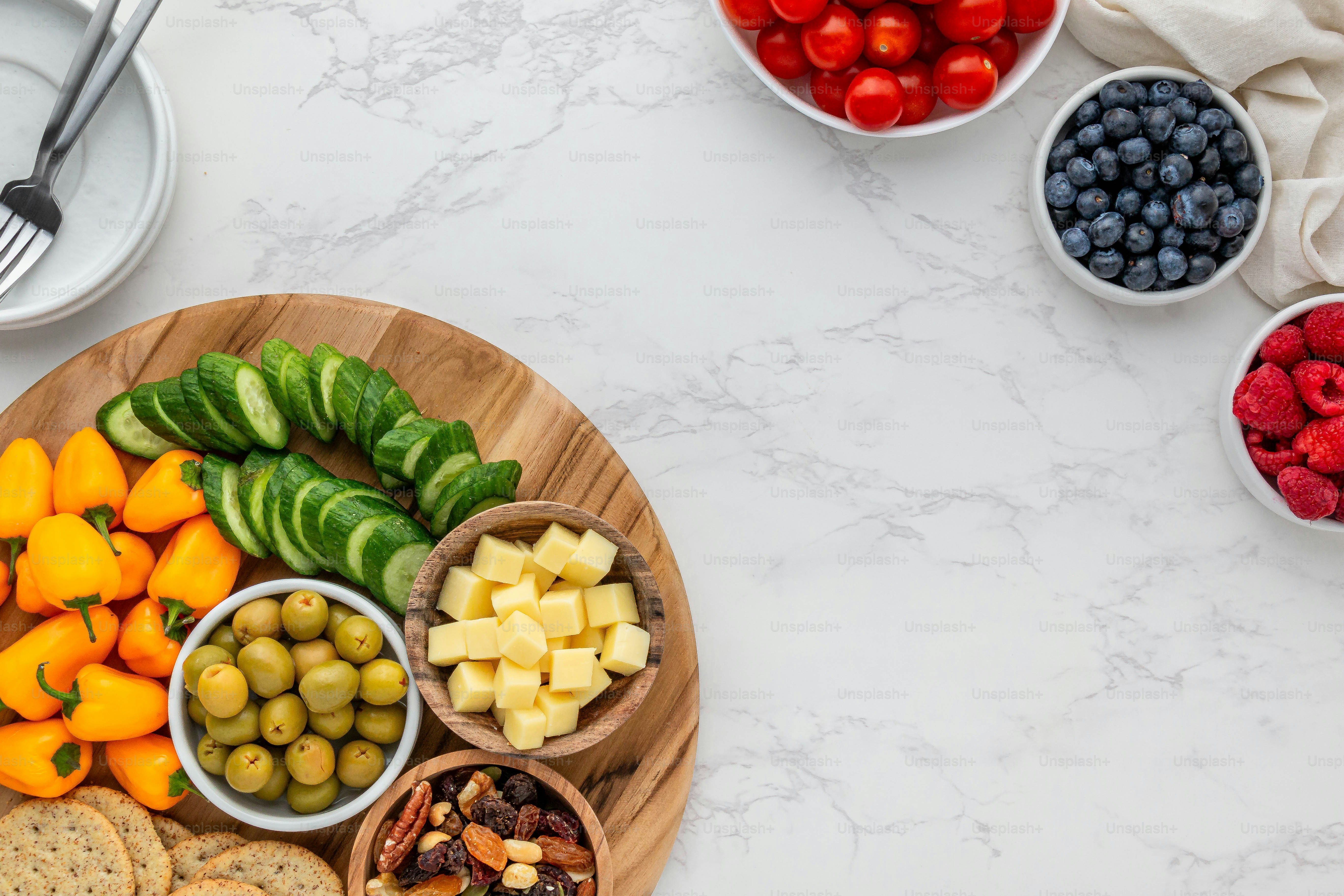 un plato de madera cubierto con frutas y verduras