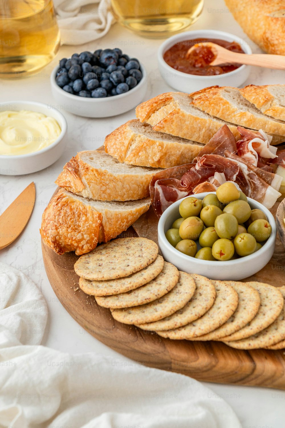 a platter of bread, olives, bread slices, cheese, and bread