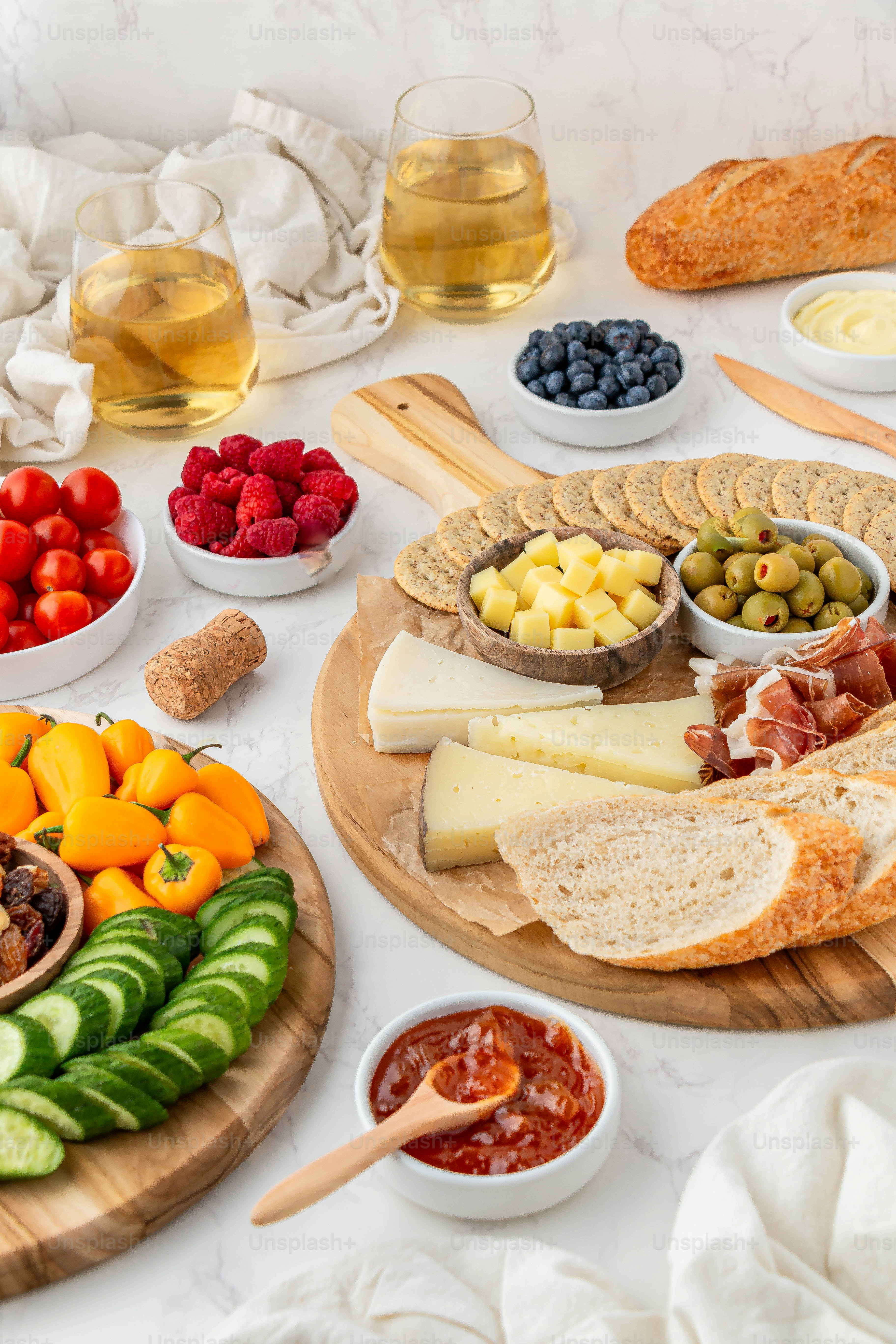 eine Platte mit Käse, Obst und Brot auf einem Tisch