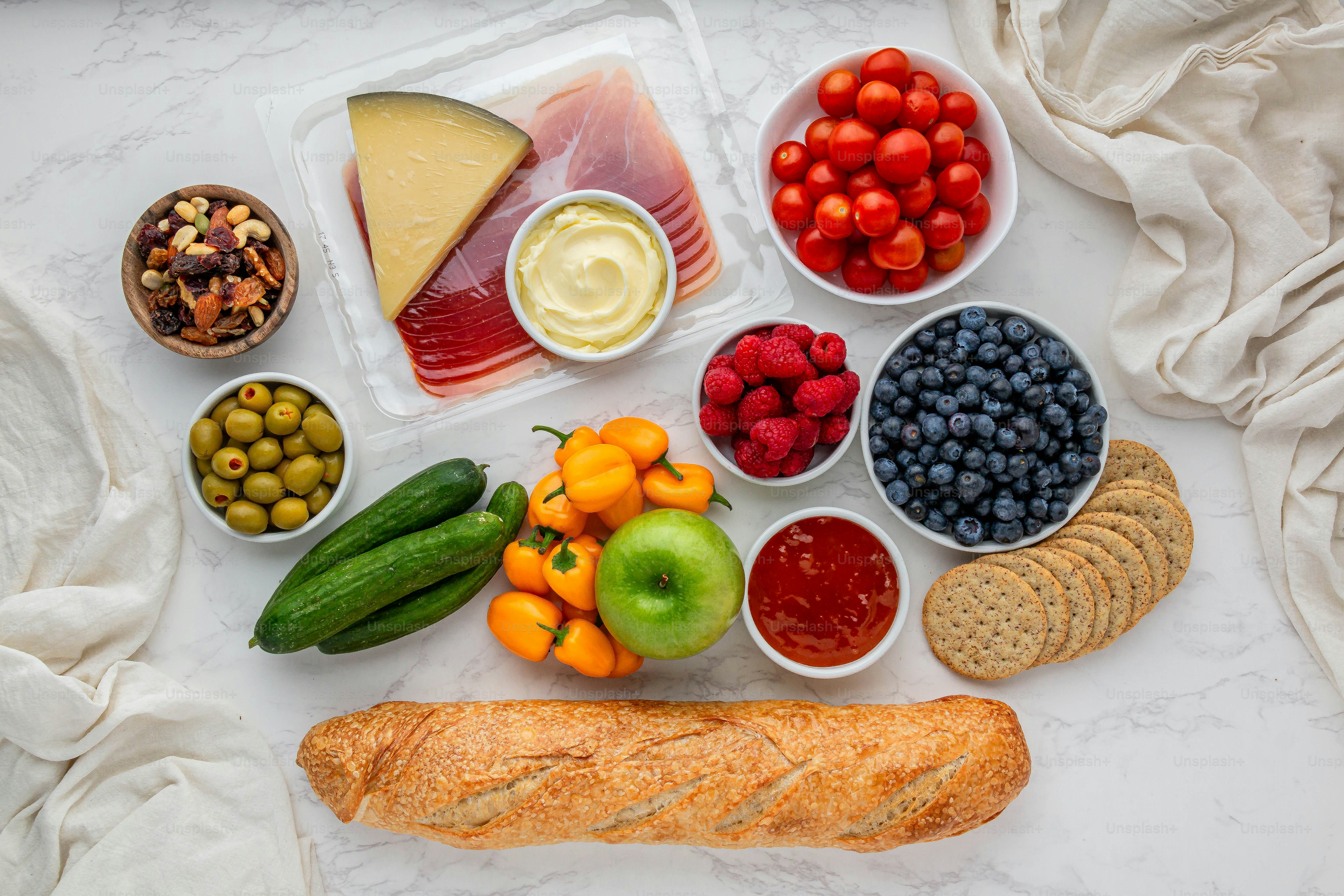 Una variedad de frutas, verduras, queso y galletas saladas en una mesa