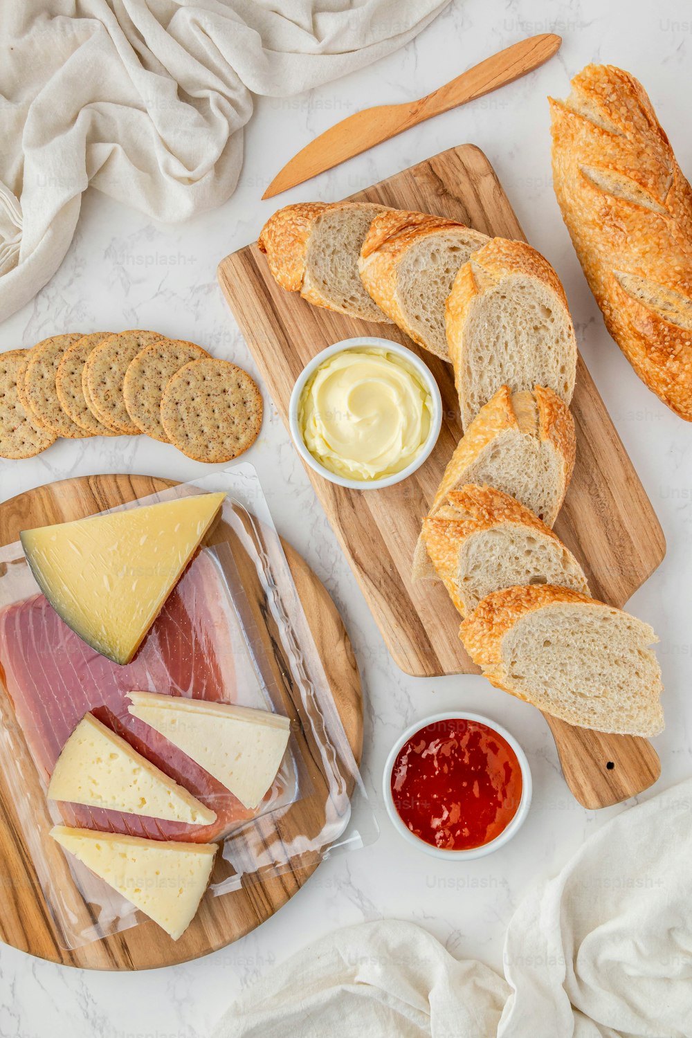 a variety of cheeses, meats, and breads on a cutting board