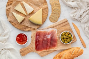 a variety of cheeses, crackers, olives, and meats on