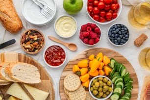 a platter of fruit, cheese, crackers, crackers, bread,