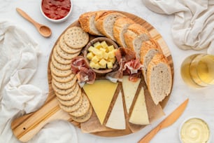 eine Platte mit Käse, Crackern und Crackern auf einem Tisch