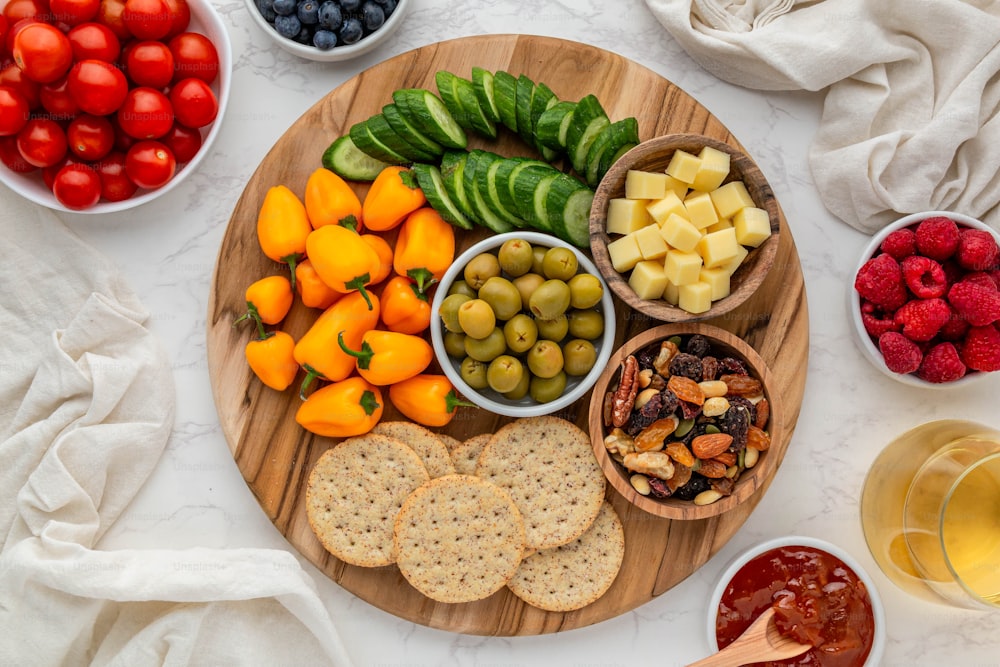 a wooden plate topped with fruit and crackers