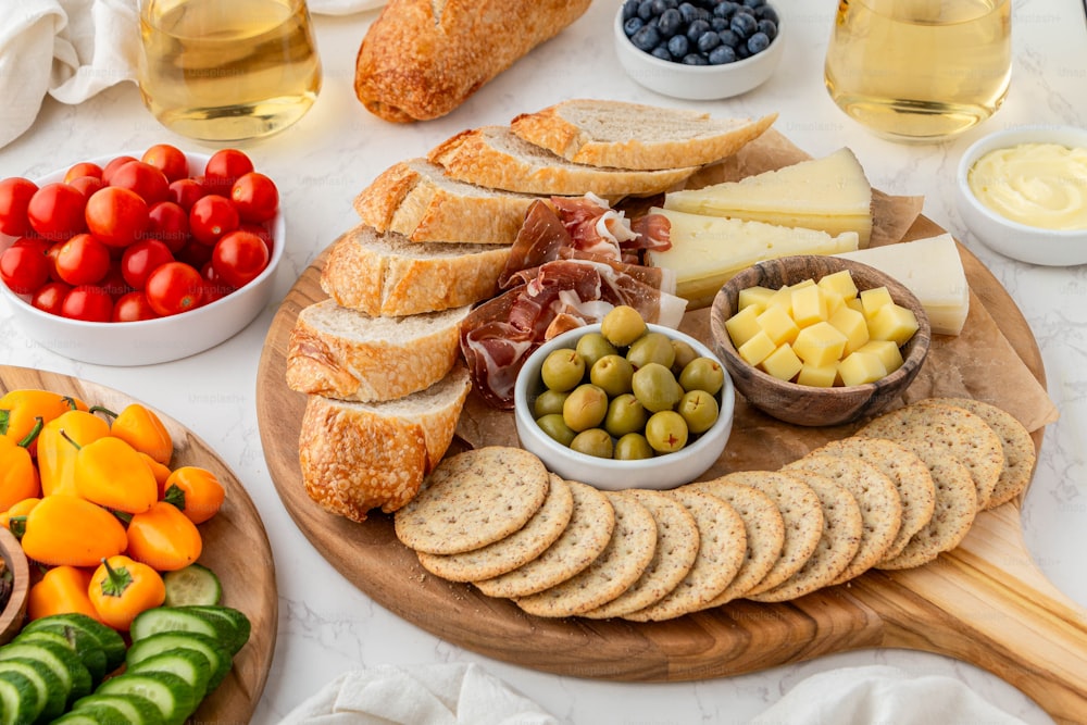 eine Platte mit Brot, Oliven, Käse und Obst