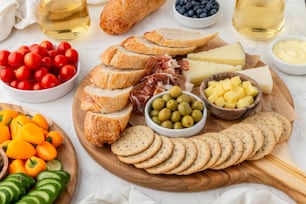 uma travessa de pão, azeitonas, queijo e frutas