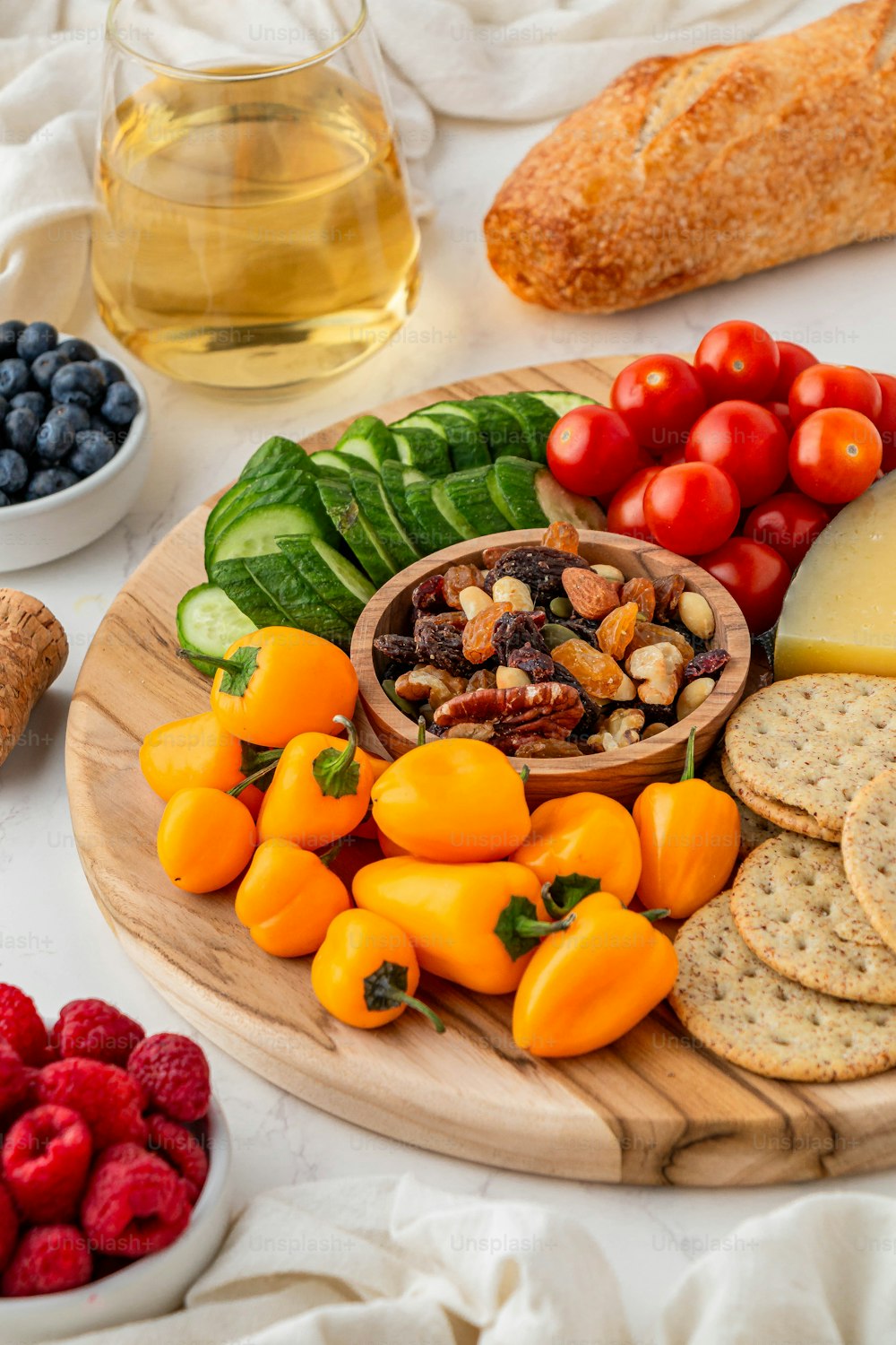 a platter of cheese, crackers, fruit and vegetables