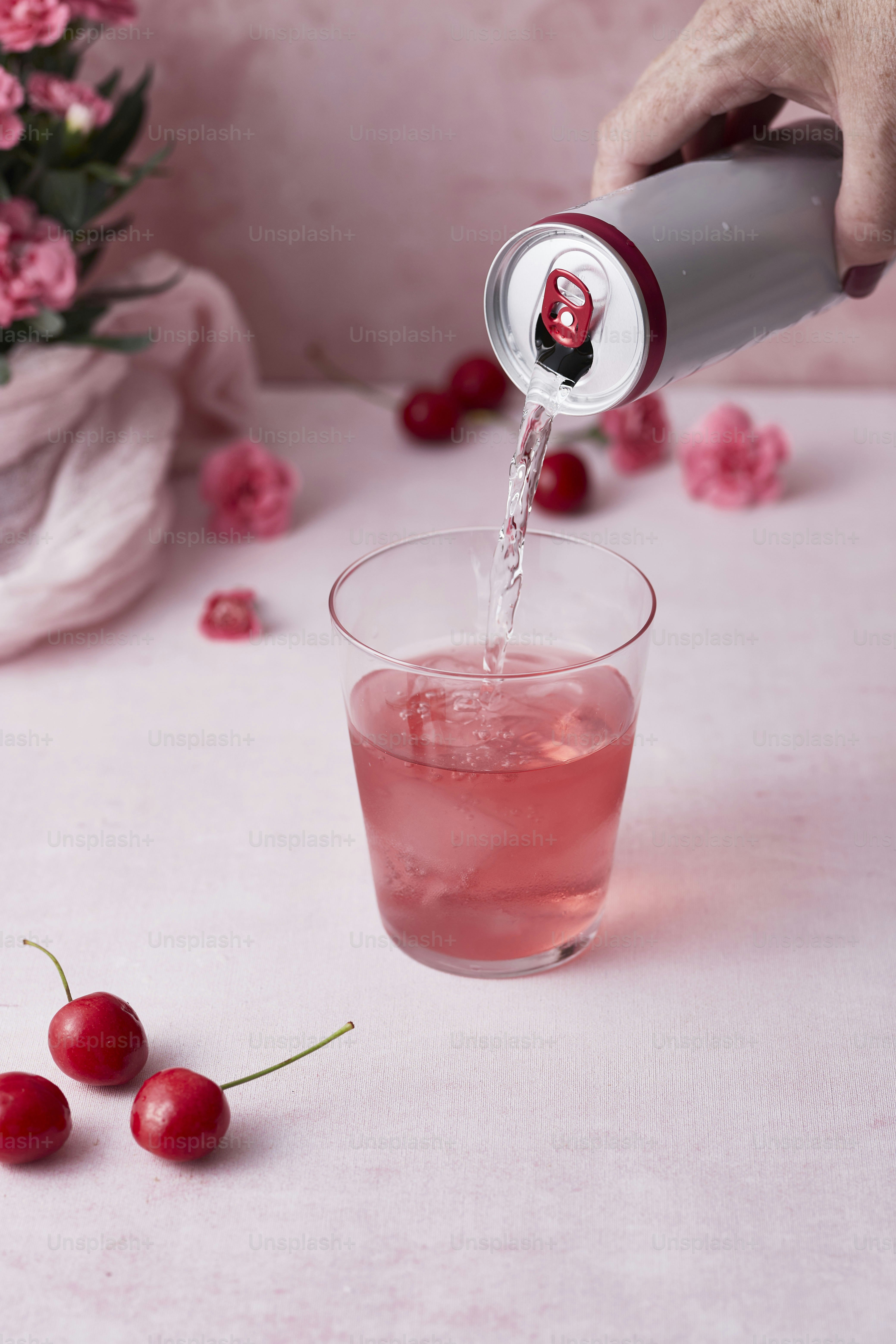 a person pouring a drink into a glass