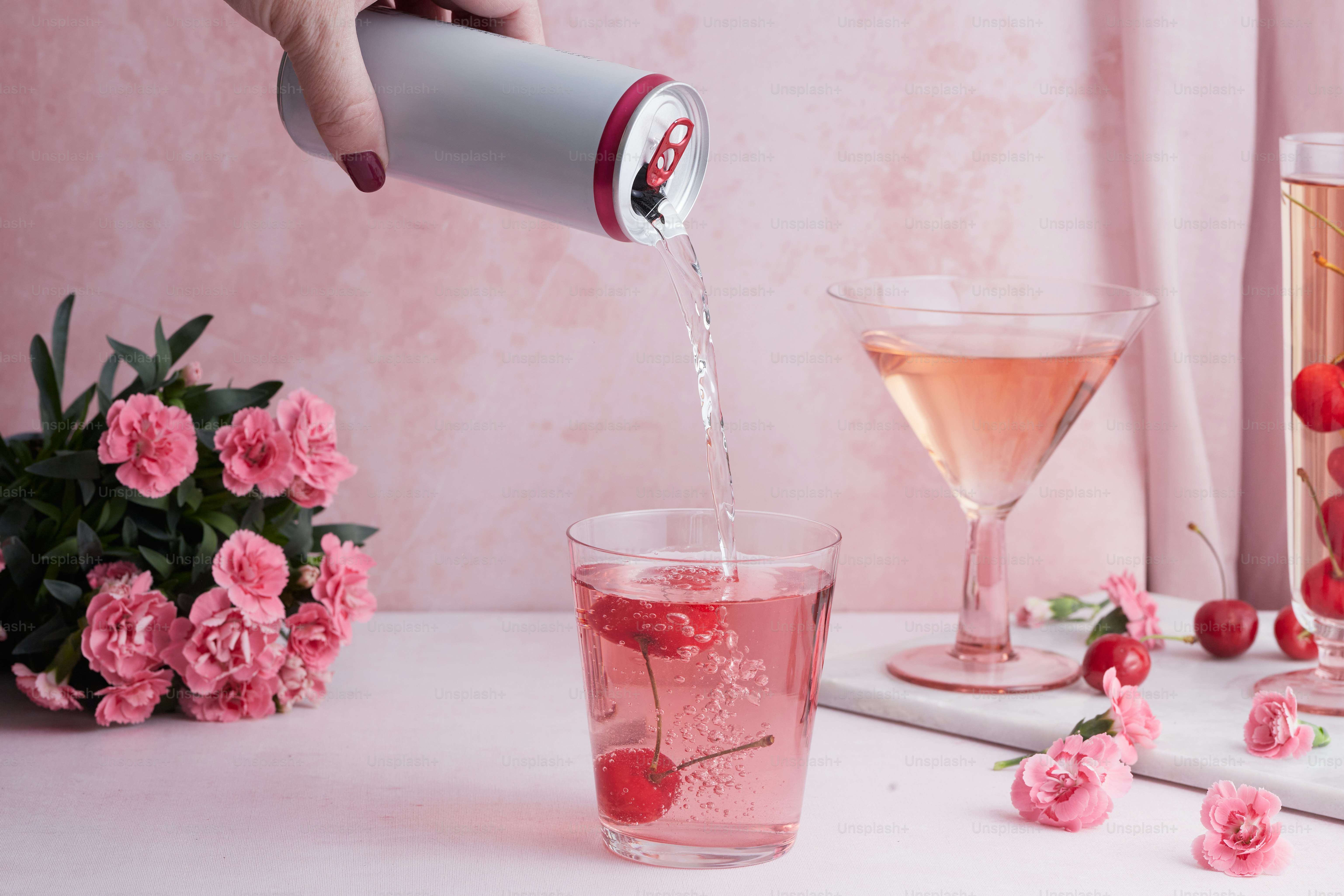 a person pouring a drink into a glass