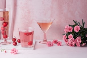 a table topped with glasses filled with liquid and flowers