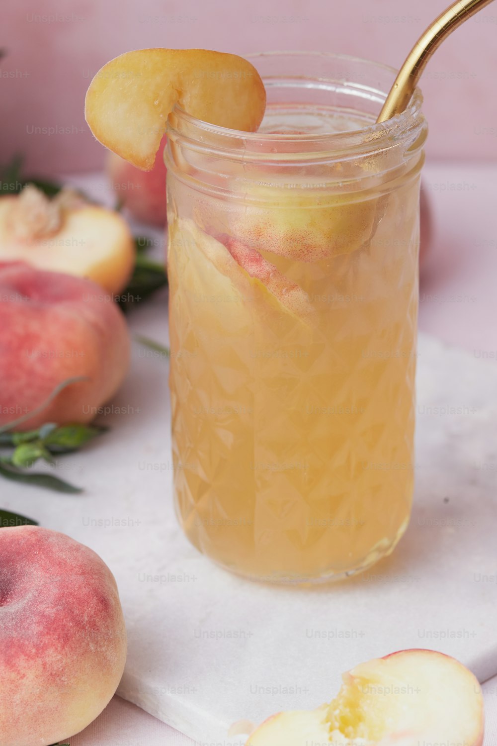 a jar of peach iced tea with a gold spoon