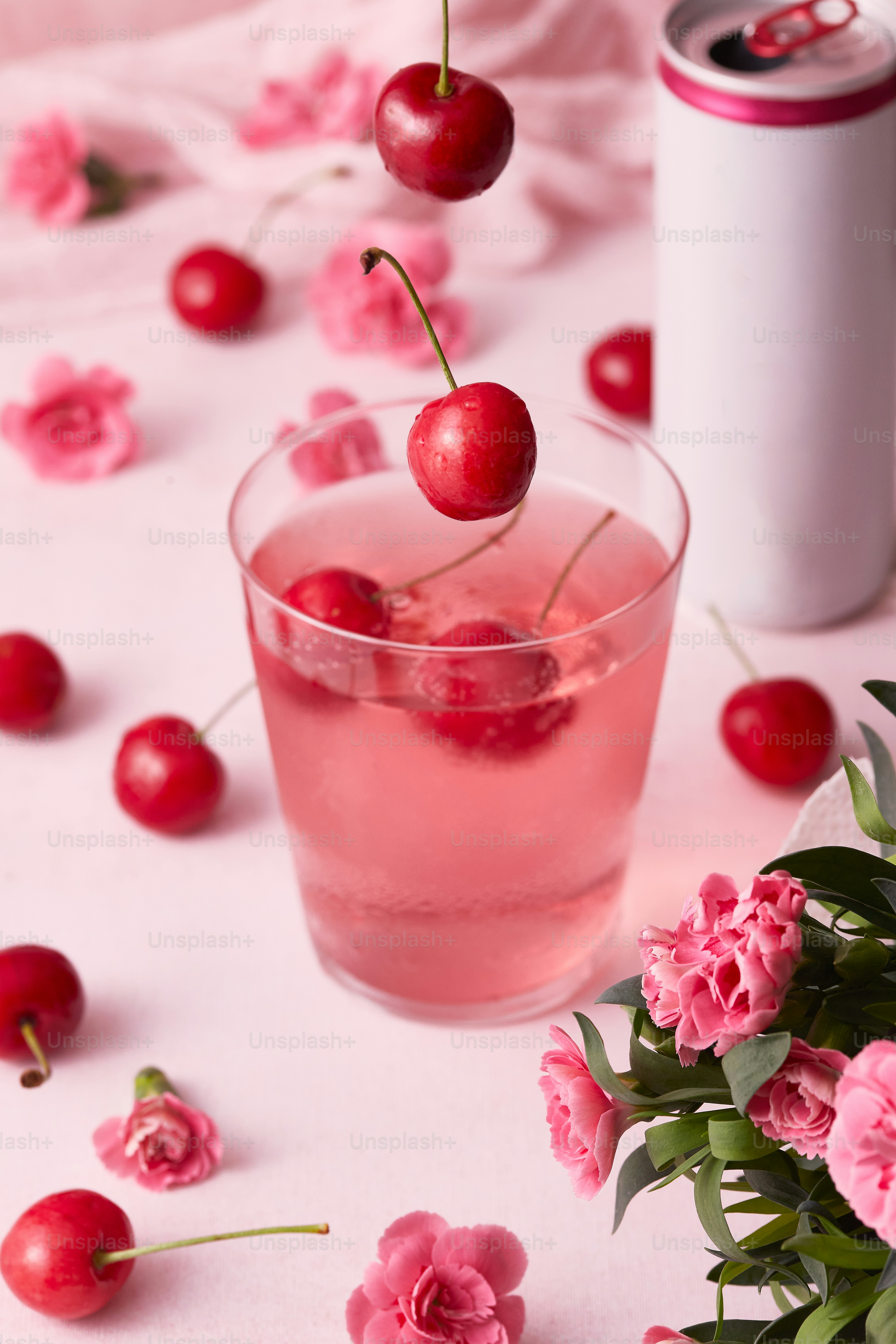 minuman merah muda dengan ceri di atas meja