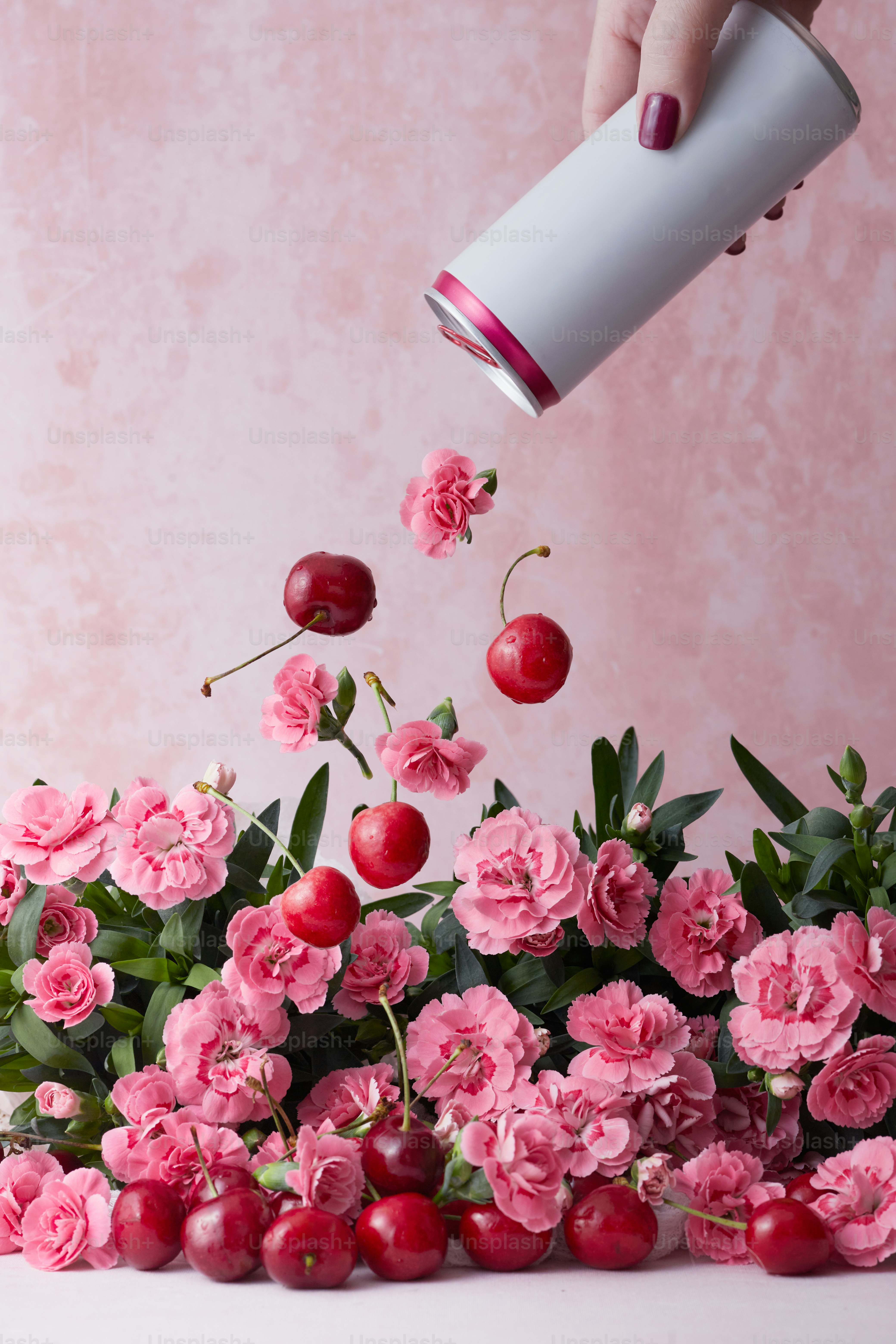 a woman is pouring cherries into a vase