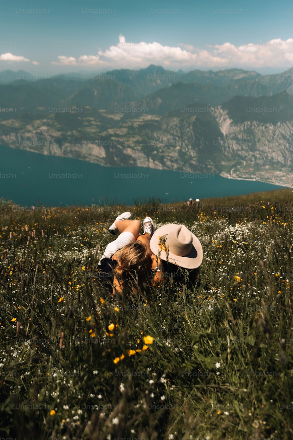 a person laying in a field with a hat on their head