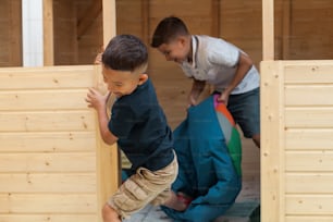 Due giovani ragazzi che giocano in una struttura di legno