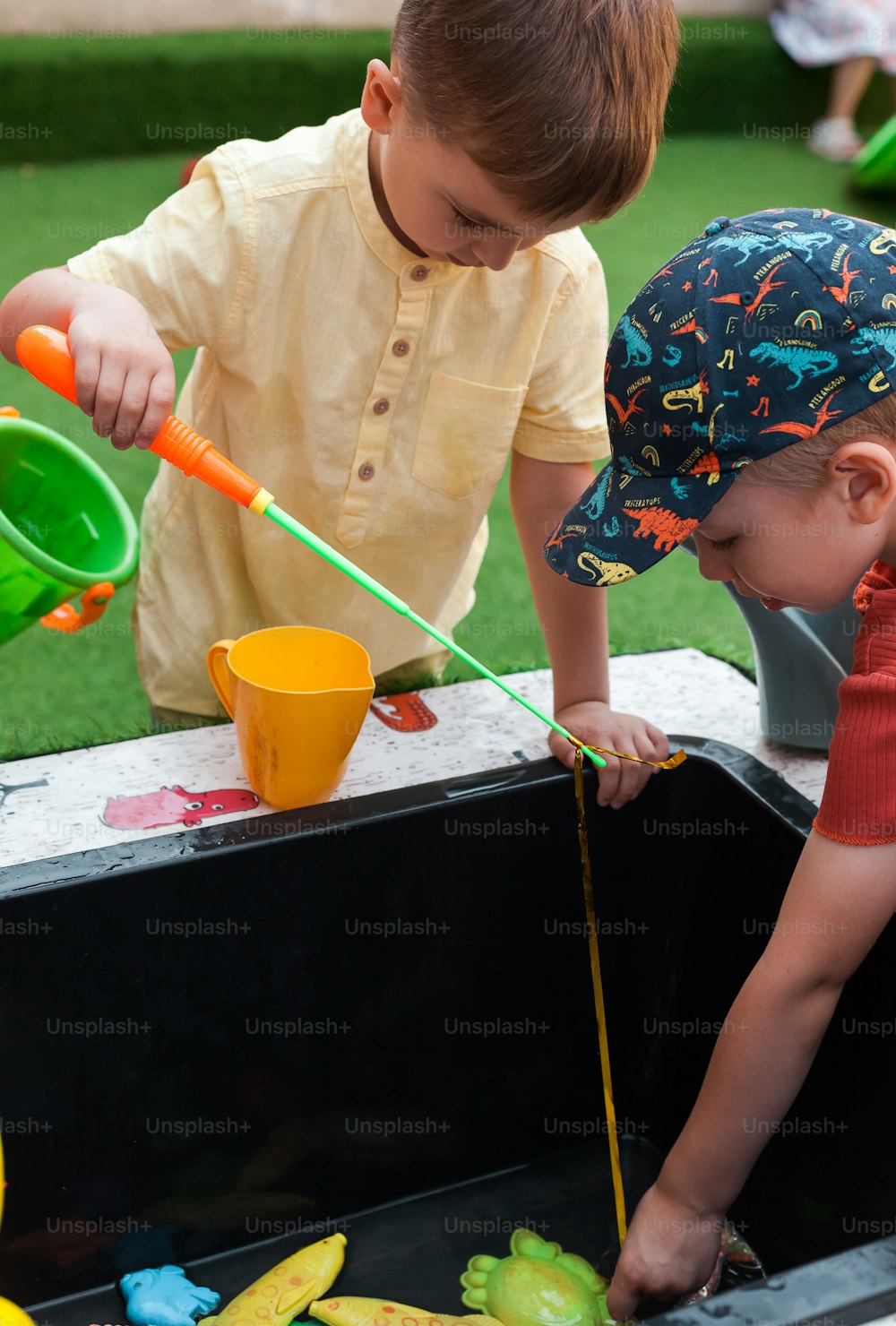two young boys playing with toys in a play area